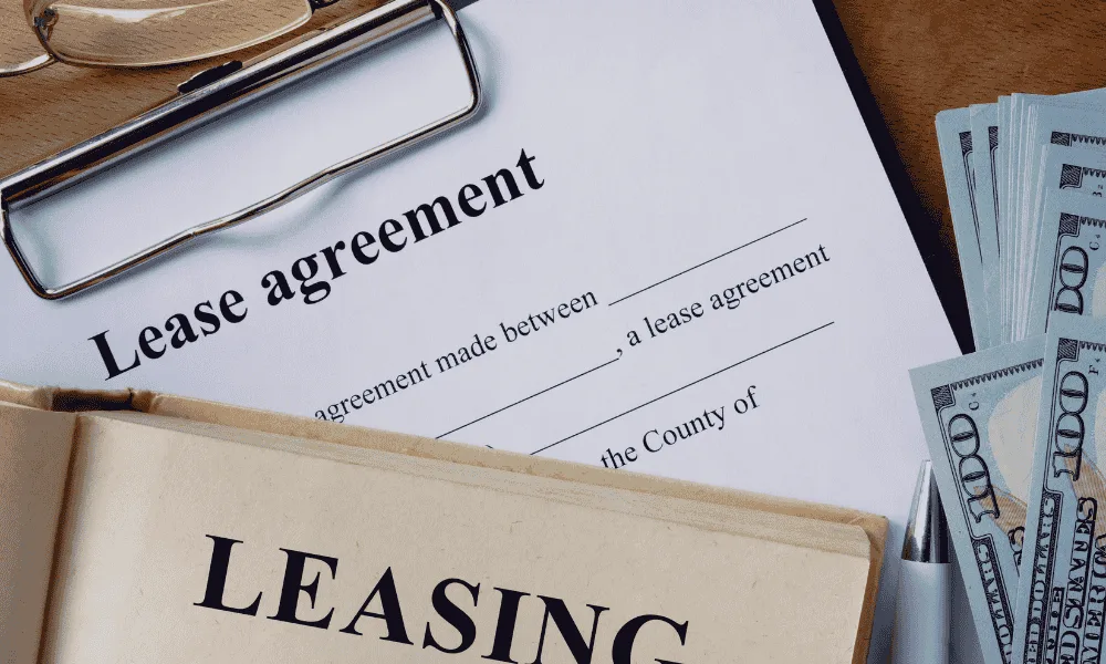 Contrato de leasing sobre una mesa, junto a unos billetes y un bolígrafo
